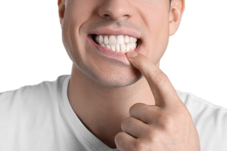 Man showing healthy gums on white background, closeup